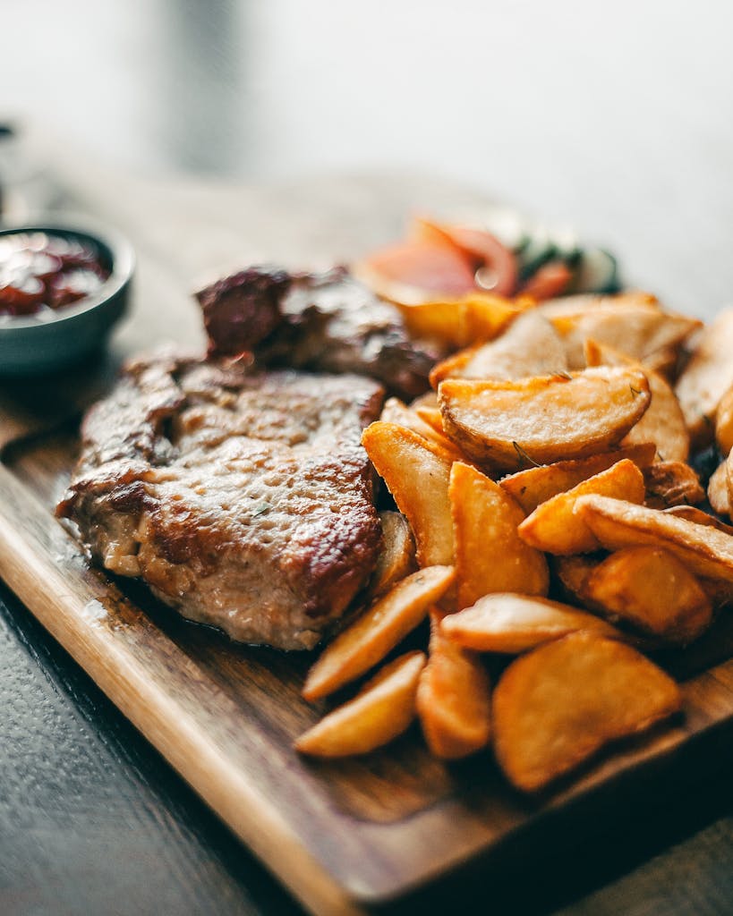 Savor a hearty meal of juicy steak with crispy potato wedges, perfect for dinner.